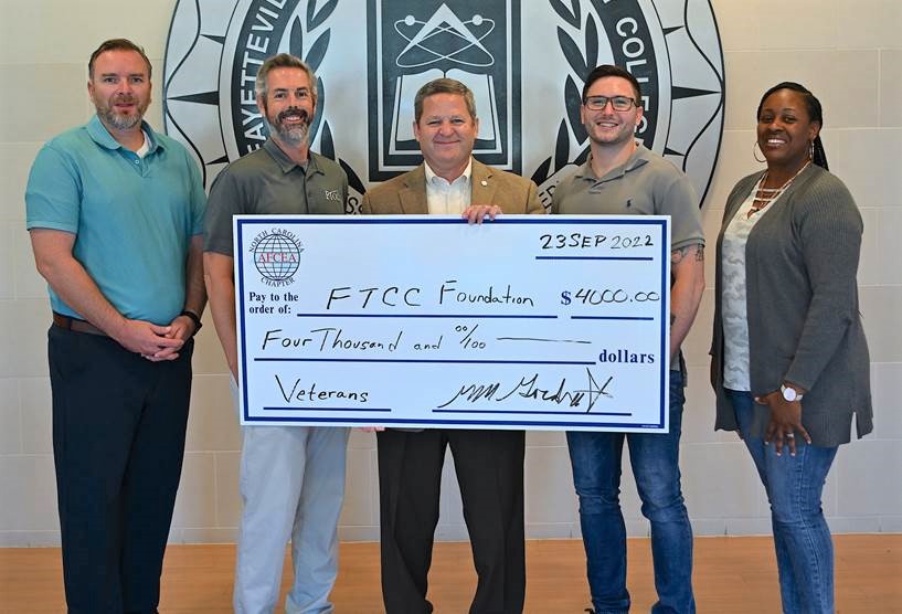 Joseph Quigley, scholarship recipient; Chris Herring, FTCC Department Chair Security Systems and Analysis; Marv Gordner, AFCEA NC Representative and FTCC Foundation Board Member; Ryan Hodgson, scholarship recipient; and Brittany Chapman, scholarship recipient, hold a giant check.
