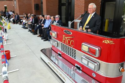 FTCC President Dr. Keen speaks at a podium designed to look like the front of a fire truck.