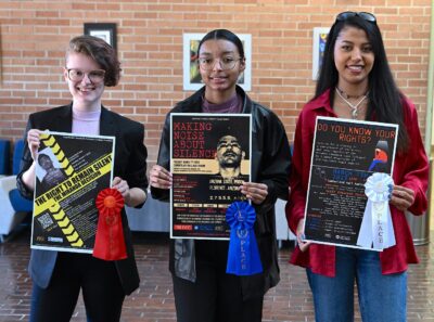 From left to right, Cheyenne Puckett, Terra Smith and Ashley Gale hold up their poster entries for the Miranda v. Arizona community discussion event.