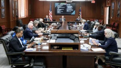 Dr. Mark Sorrells sits at the far end of a table where several men and women are sitting in a board room.