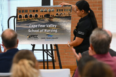 A FTCC Tom McLean Student Ambassador reveals a rendering of the Cape Fear Valley School of Nursing.