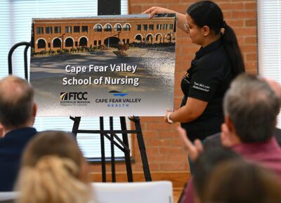 A FTCC Tom McLean Student Ambassador reveals a rendering of the Cape Fear Valley School of Nursing.