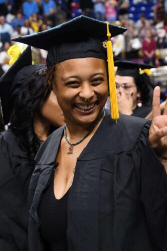 A-graduate-smiles-broadly-and-waves