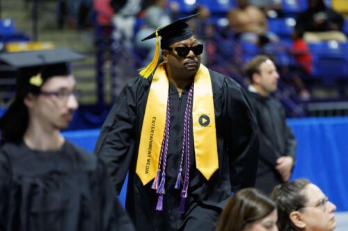 A-graduate-wears-sunglasses-and-a-stole-indicating-his-degree-in-Entertainment-Media