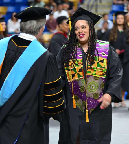 Dr.-Sorrells-congratulates-a-smiling-graduate-in-a-colorful-stole