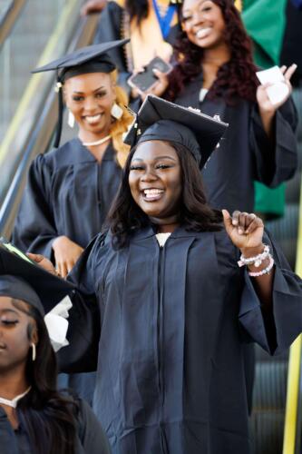 Several-graduates-beam-as-they-ride-down-the-escalator-on-the-way-to-the-Crown