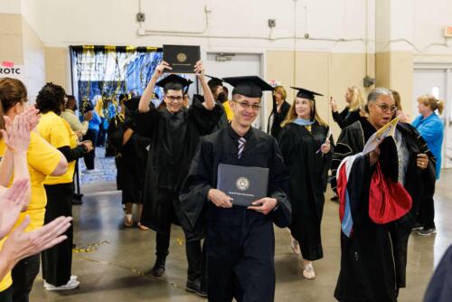 Two-graduates-celebrate-as-they-enter-the-Expo-Center-after-the-Commencement-ceremony-surrounded-by-faculty-and-greeted-by-excited-FTCC-staffers