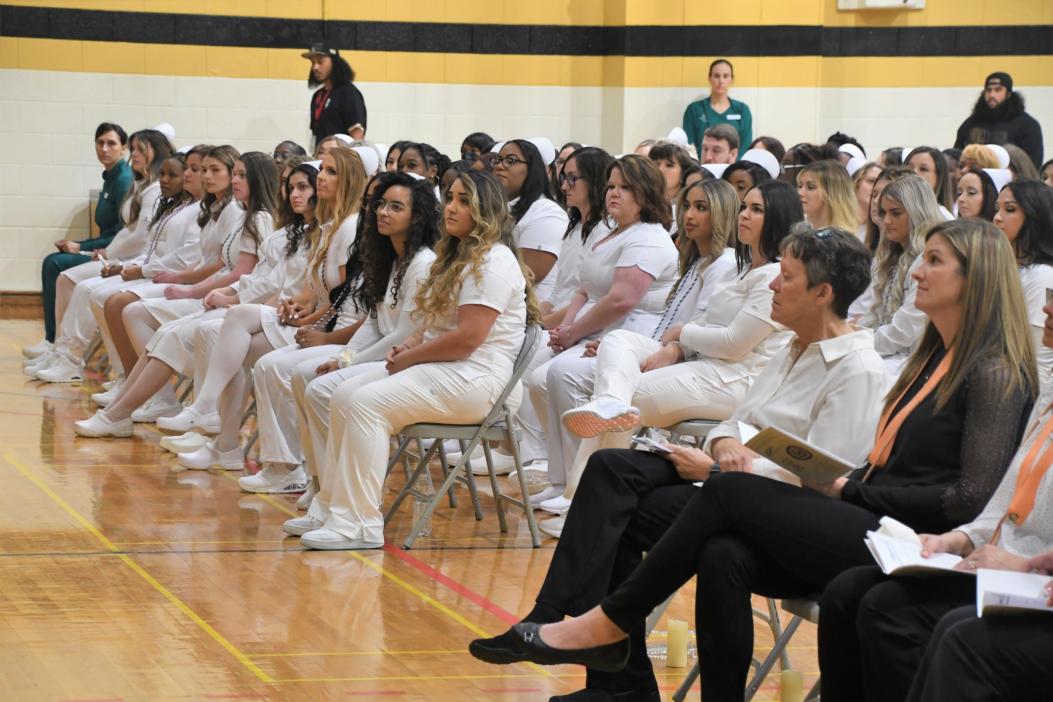 A wide photo of the ADN graduates seated in the audience.