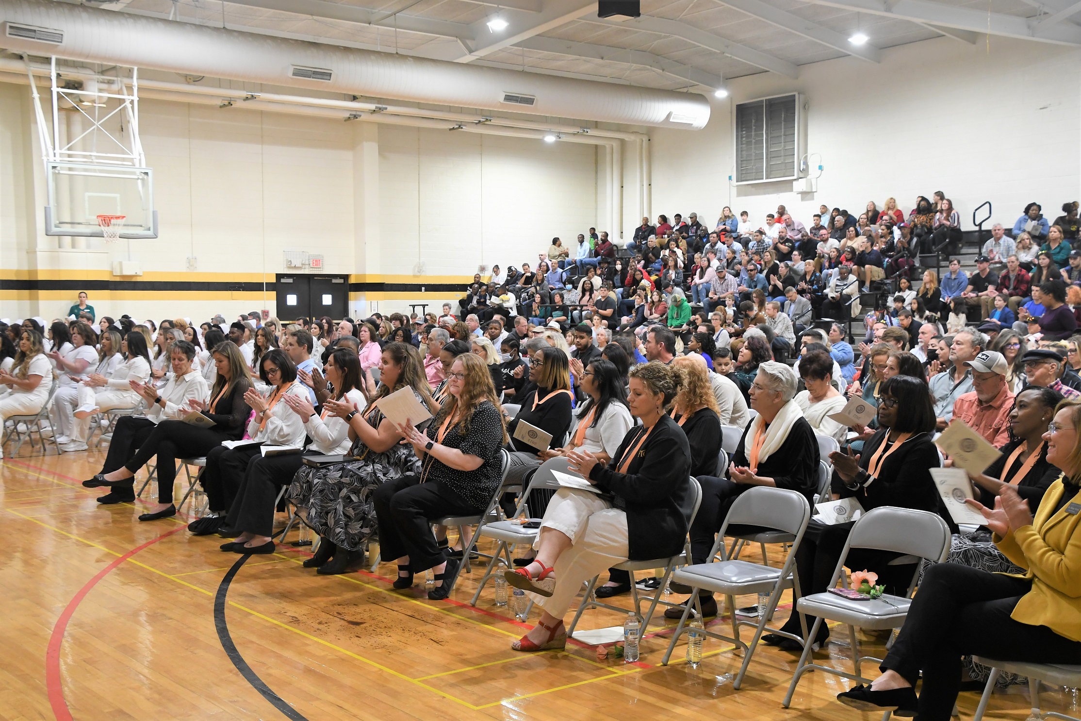A wide photo of the audience in the gymnasium at the ADN pinning ceremony.