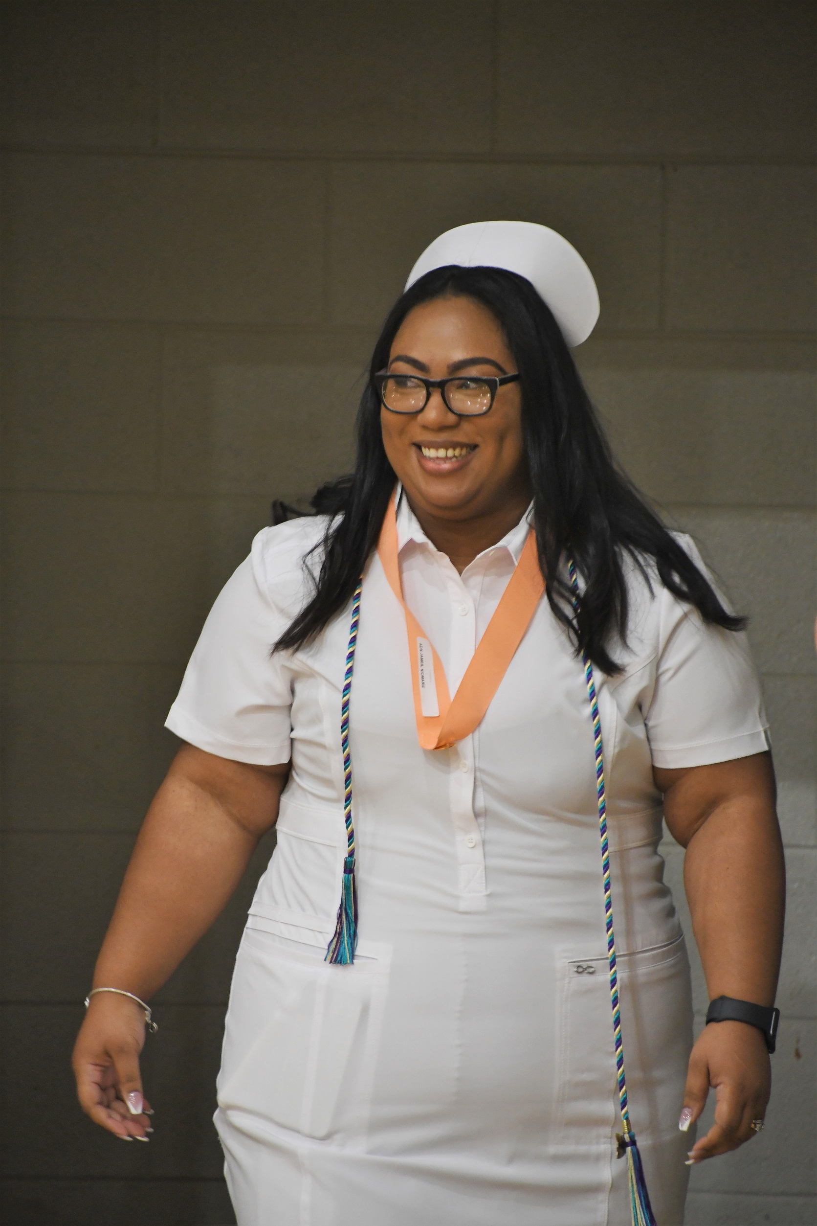 An ADN graduate walks back to her seat after receiving her pin.