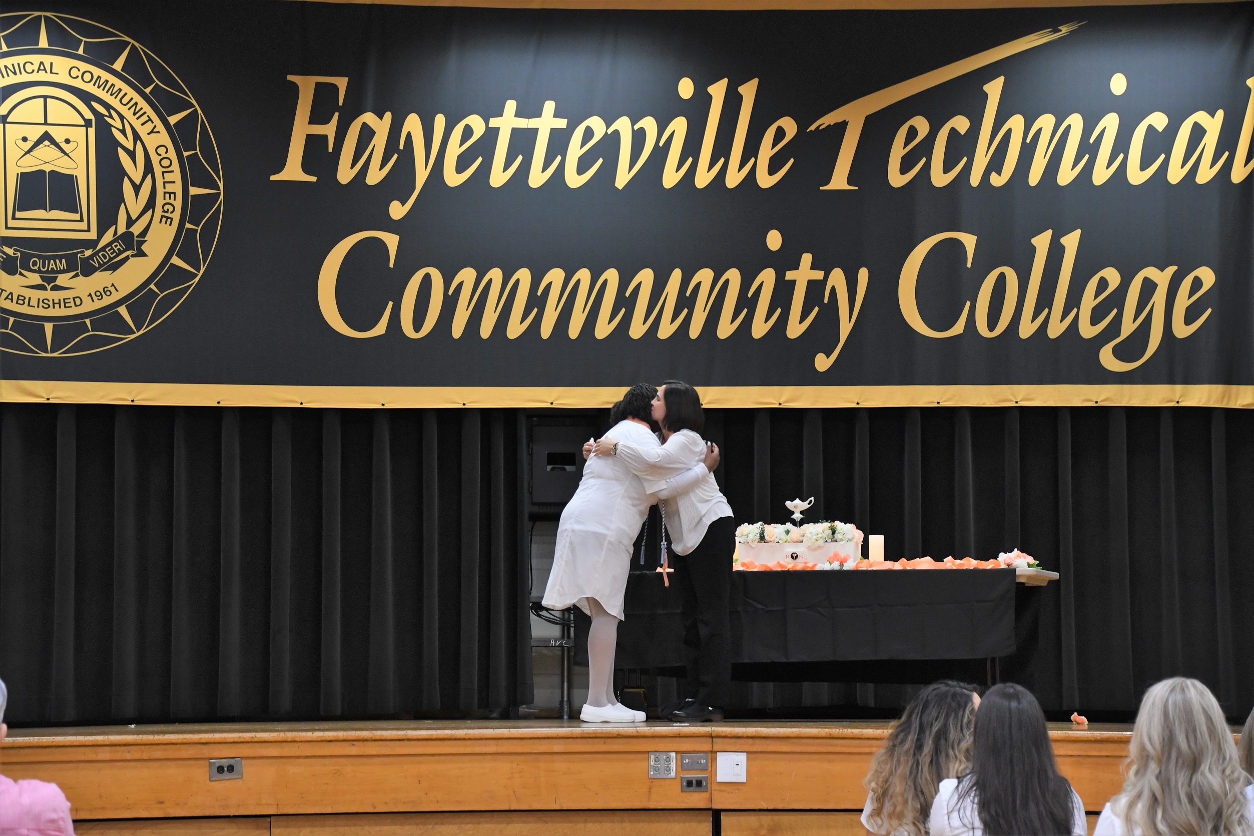 An ADN graduate receives a hug after getting her pin.