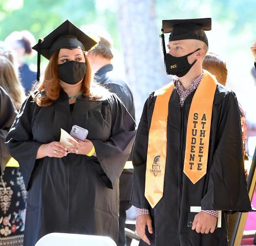 008 - Two graduates stand inside a tent