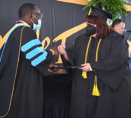 027 - Dean Jackson fist-bumps a graduate in Tent B