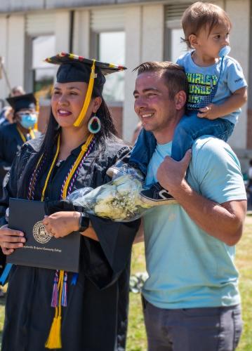 041 - A graduate stands with others after the ceremony