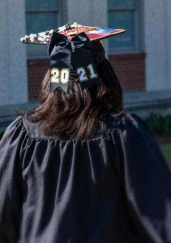 055 - A graduate wears a mortarboard with a bow emblazoned with 2021