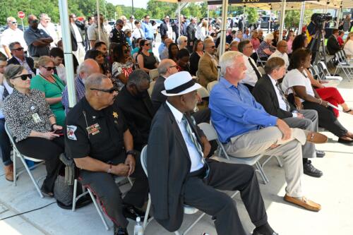 Attendees sit under a canopy listening to speakers at the hose uncoupling ceremony.
