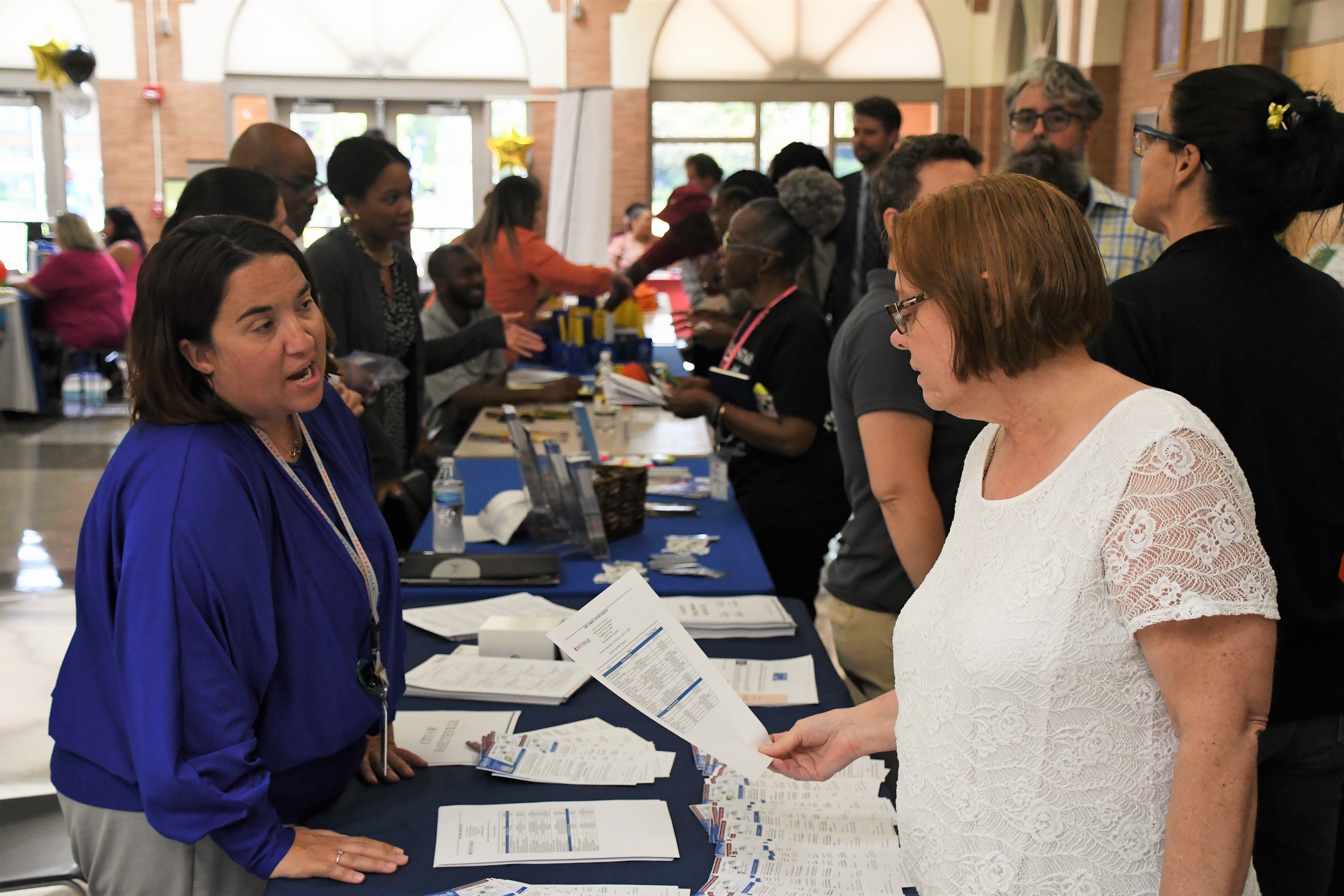 A job seeker looks over a piece of paper at a booth at the Expo.