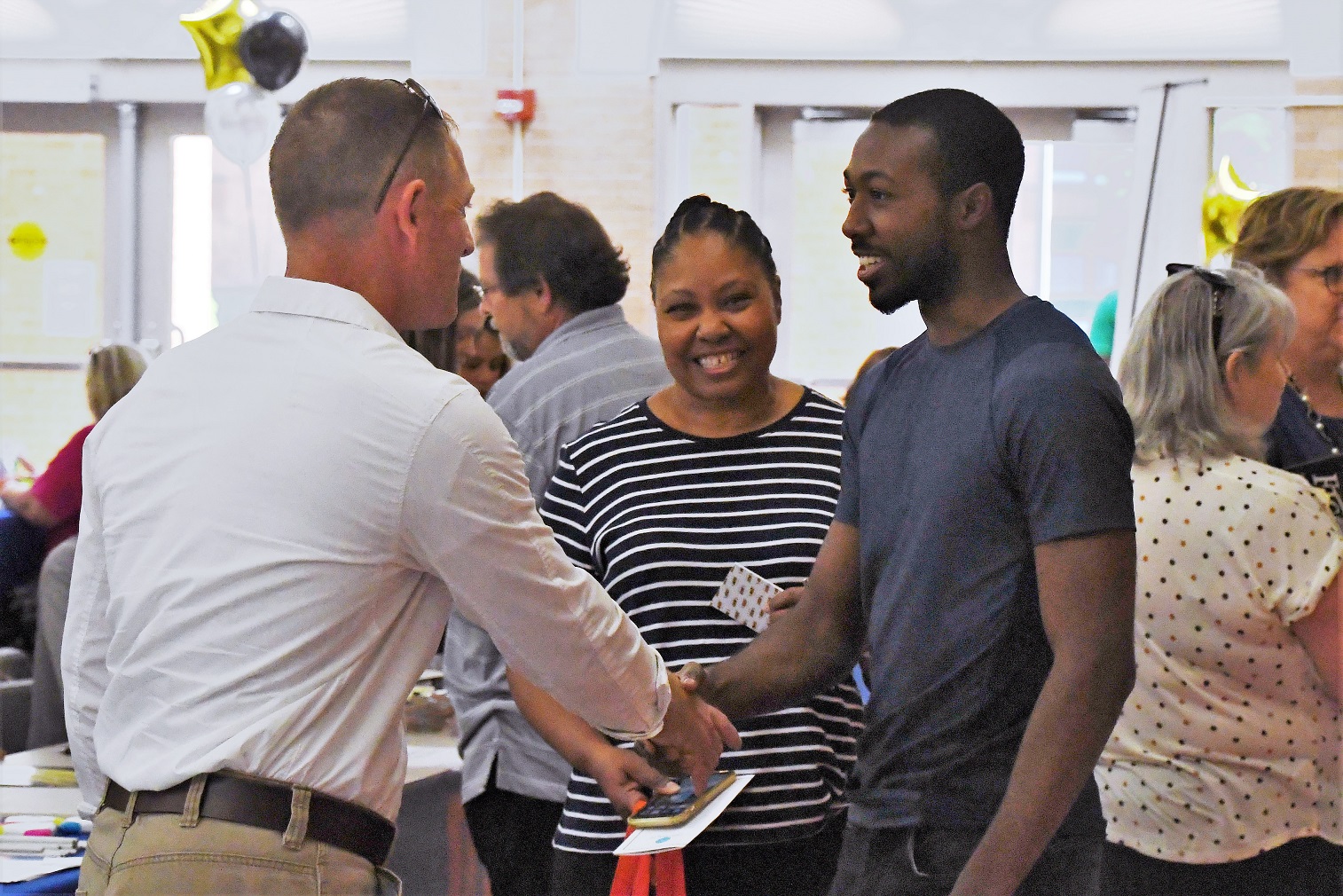 An employer shakes hands with a job seeker at the Expo.