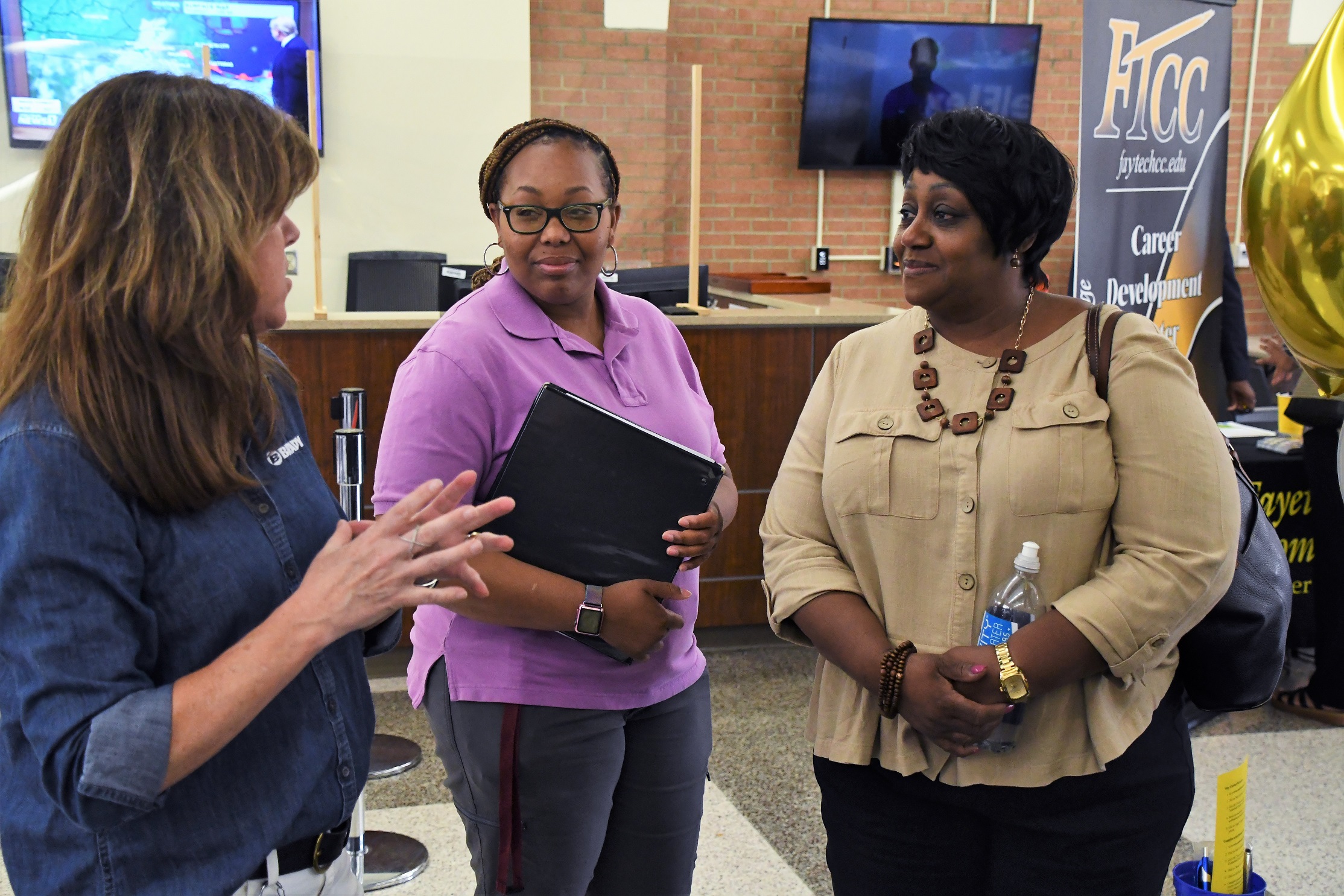 Three women talk at the Expo.