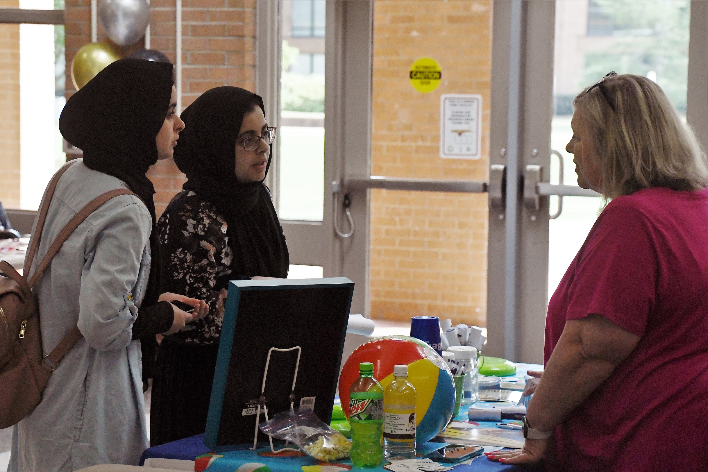 Three women talk at a table at the Expo.