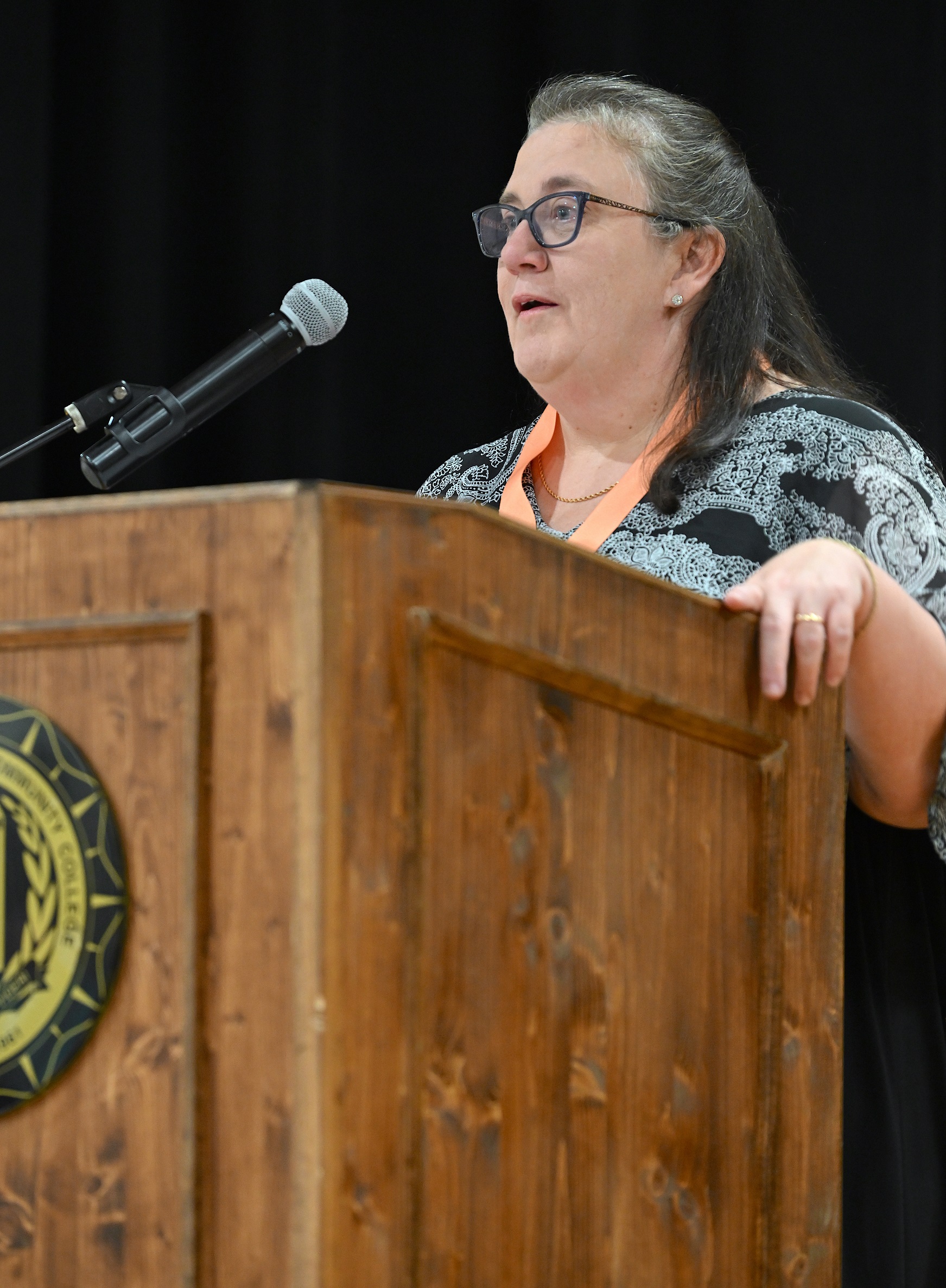 Sharon Gallagher speaks at the podium during the pinning ceremony.