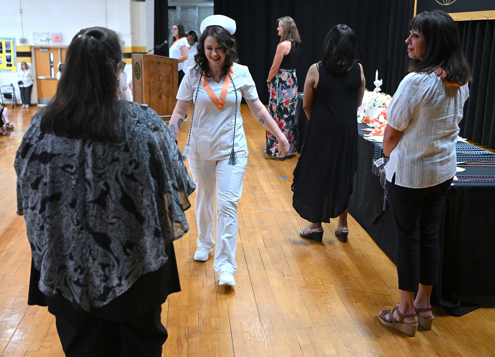 A graduate walks across the stage after receiving her pin.