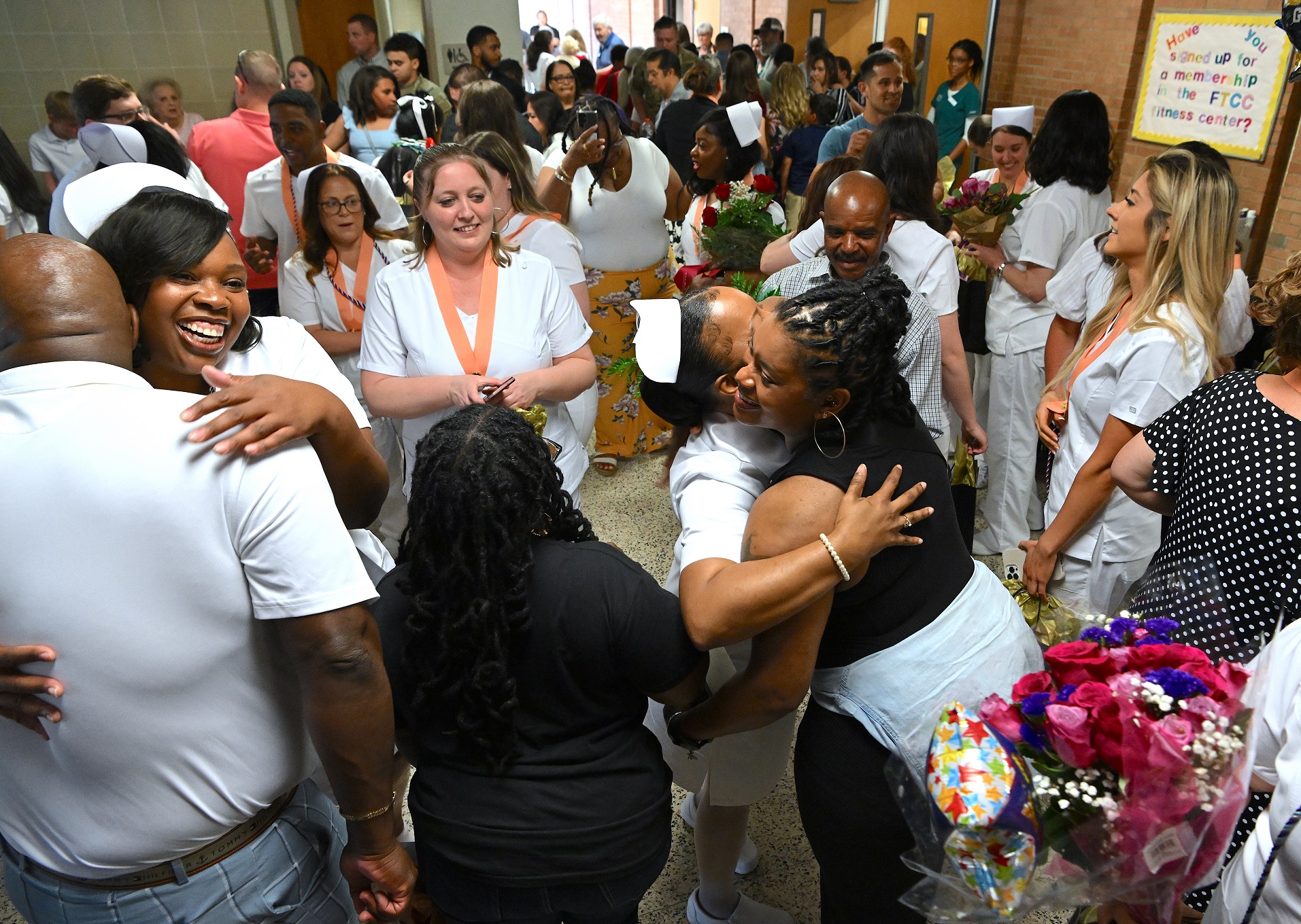 A photo of a packed hallway where Nursing graduates and their loved ones celebrate.