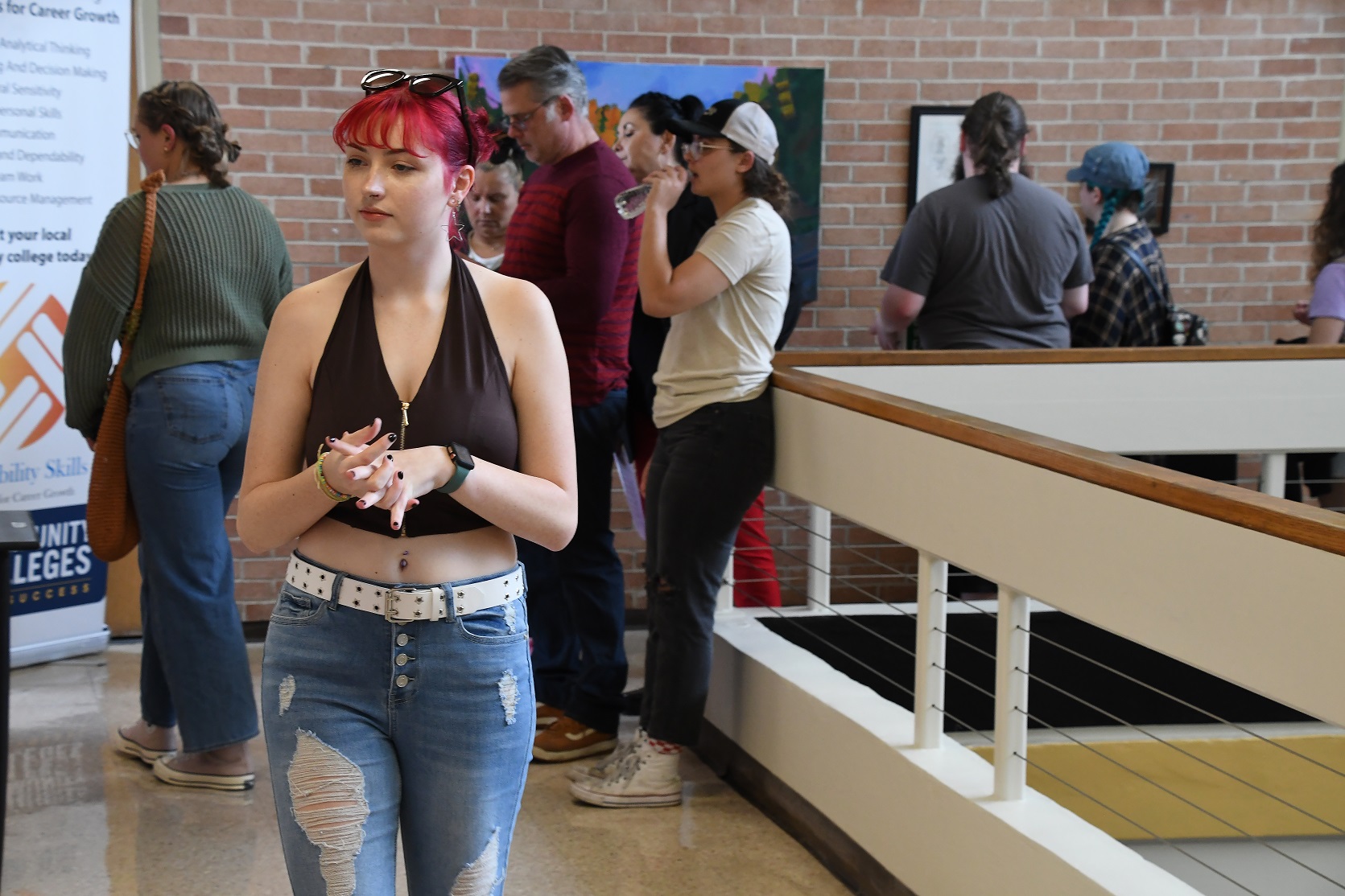 A visitor looks at the art on the second floor of the library.