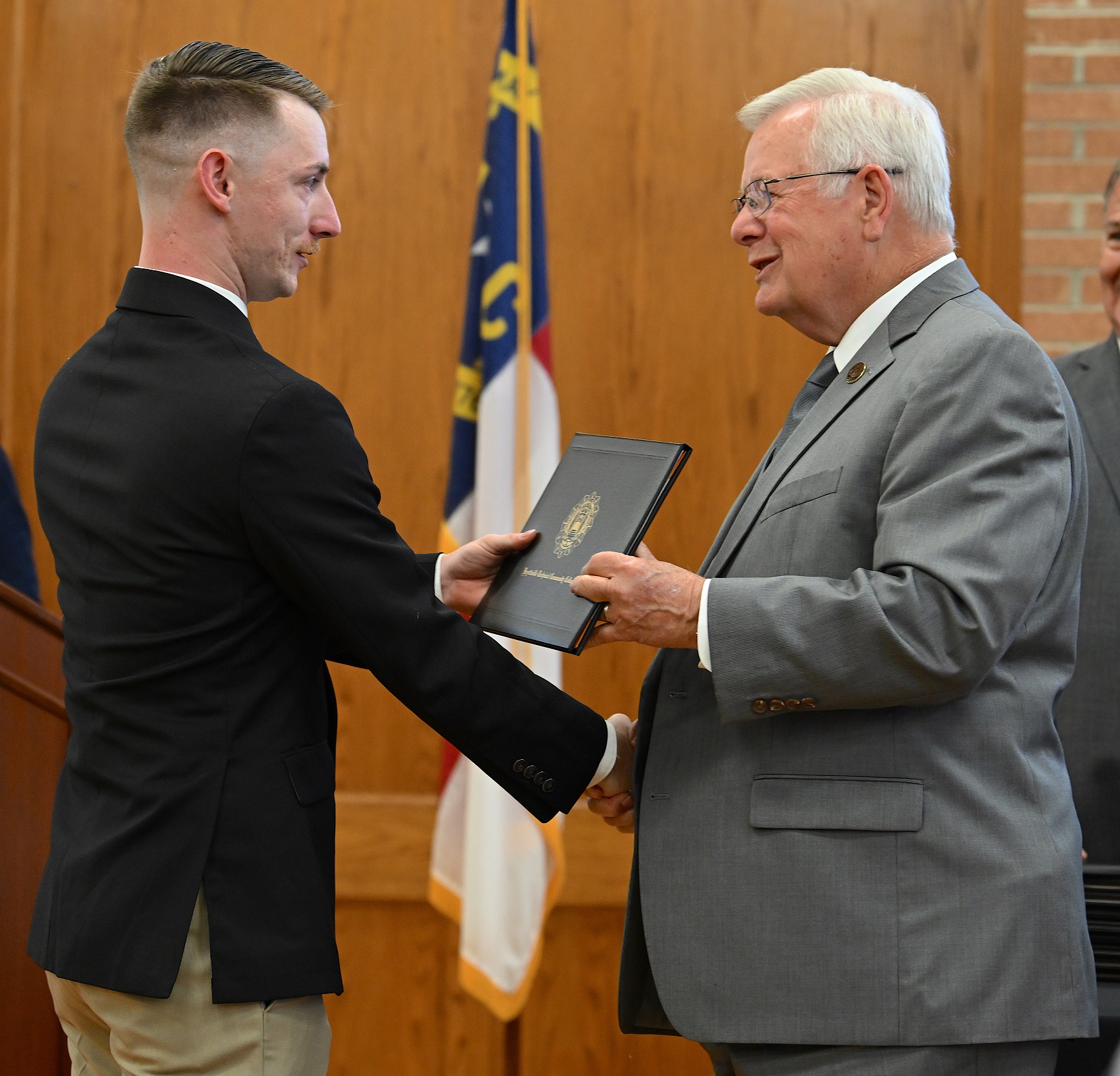 Philip Flick accepts his certificate and shakes hands with Dr. Keen.