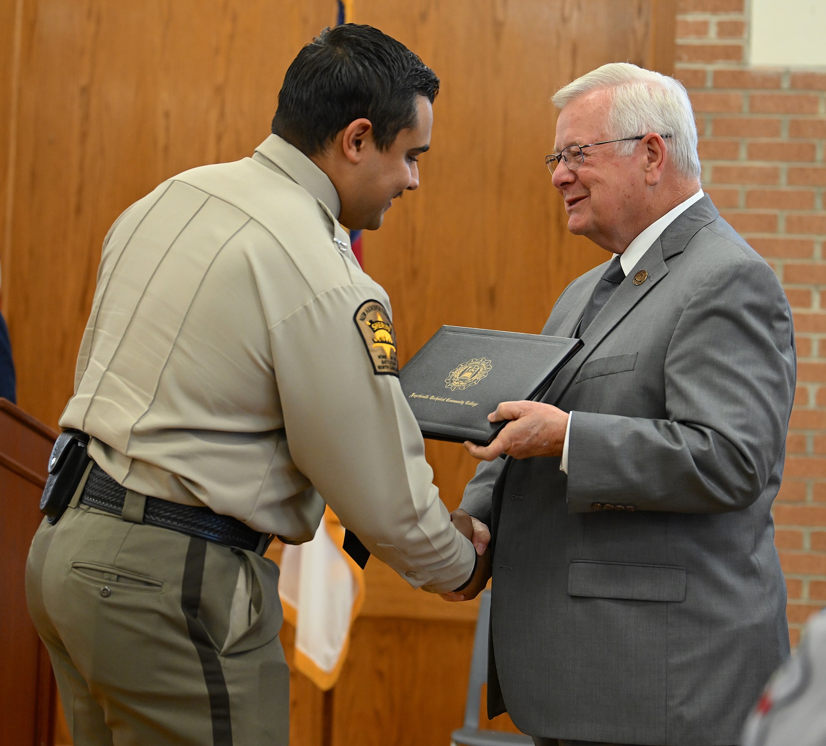Chandler Whitfield accepts his certificate and shakes hands with Dr. Keen.