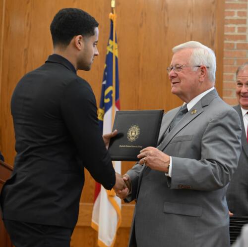 Alejandro Estrella accepts his certificate and shakes hands with Dr. Keen.