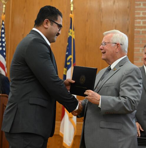 Paulo Paulo accepts his certificate and shakes hands with Dr. Keen.