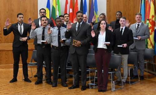 The BLET graduate stand with their right hands raised to swear the oath.