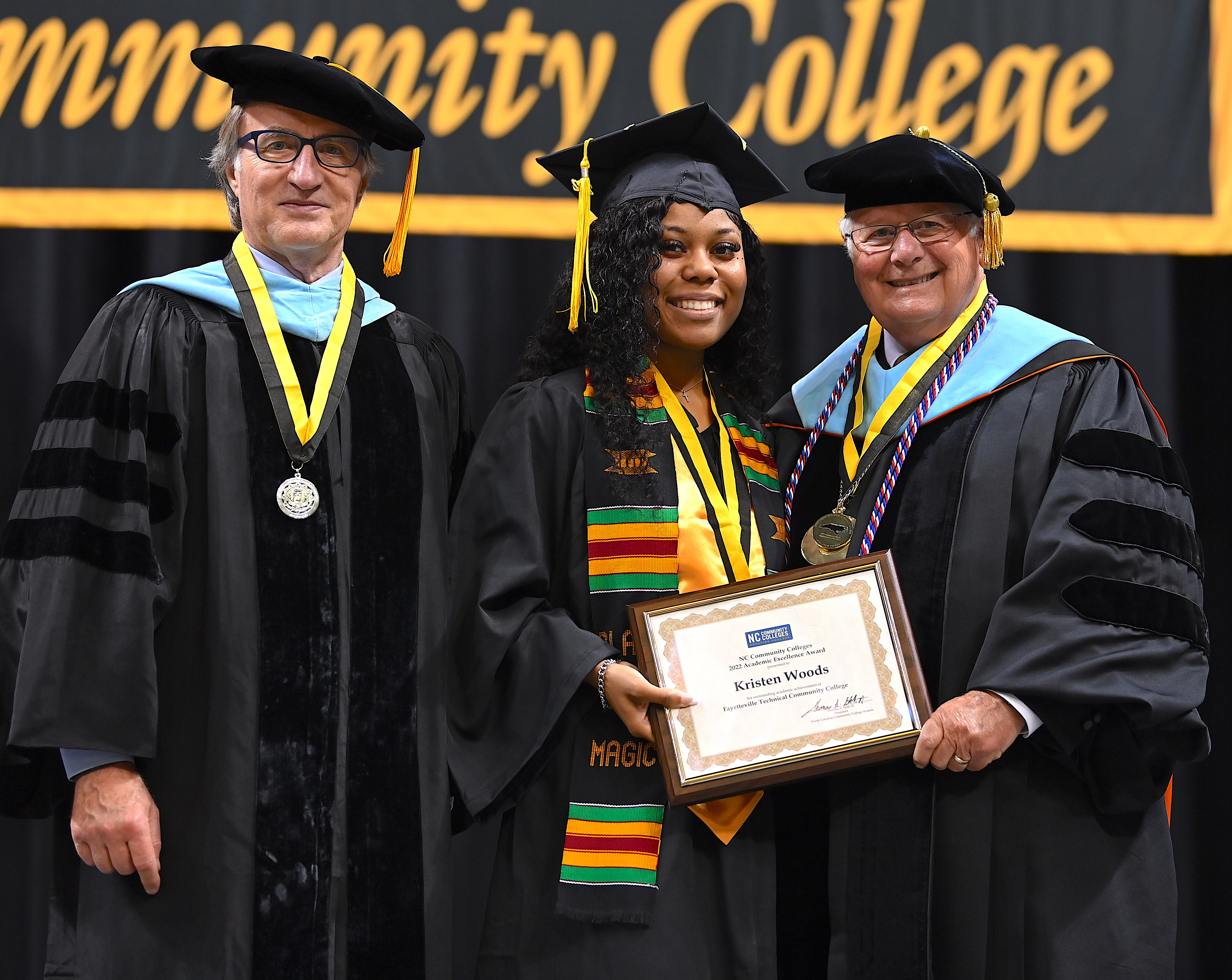 Kristen Woods poses for the camera with her award. Dr. Mark Sorrells and Dr. Larry Keen stand on either side of her.