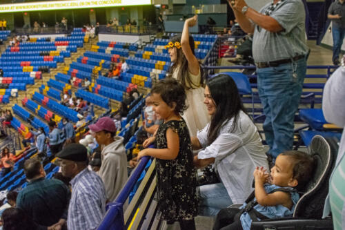 Audience members watch the graduation from the stands.