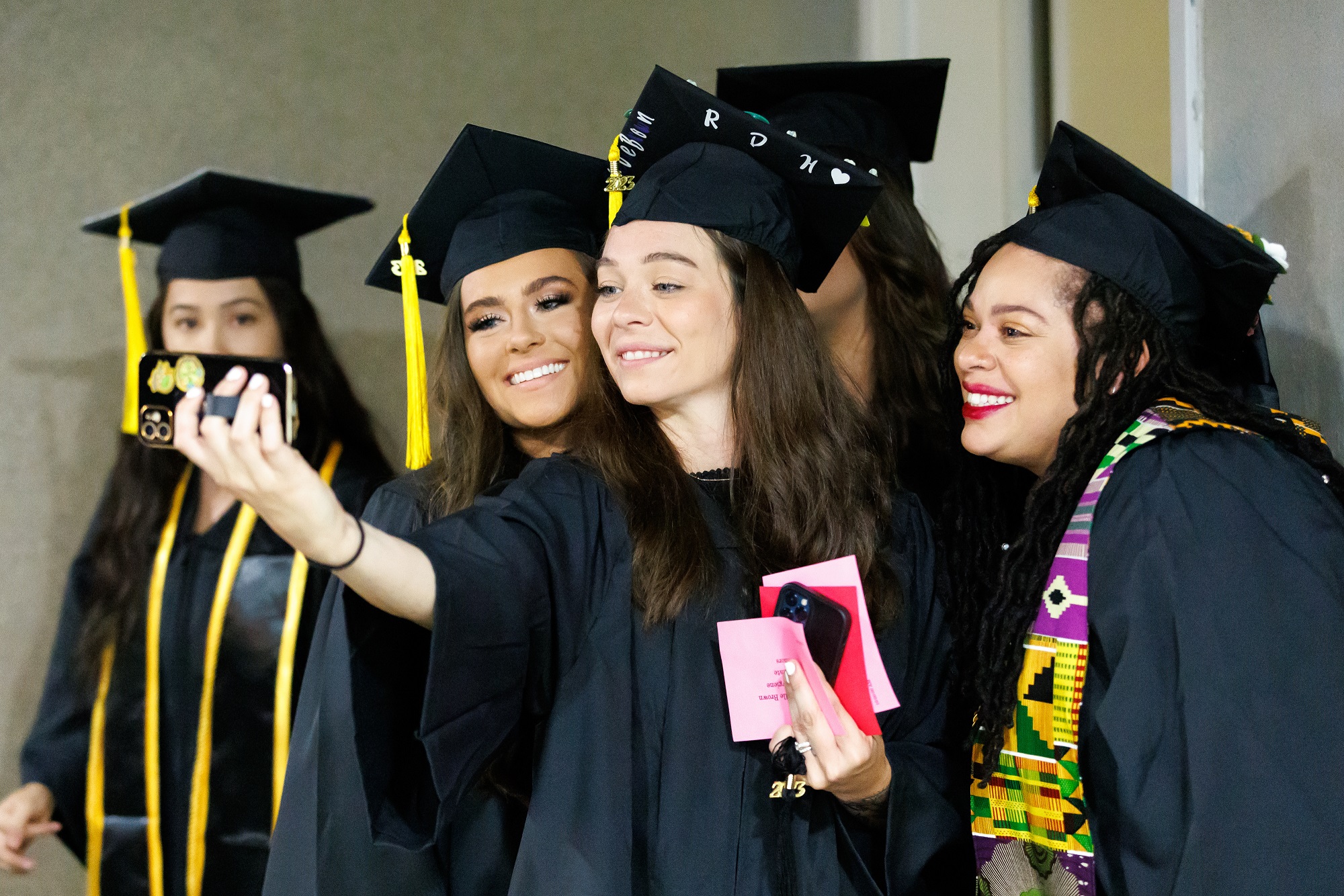 A group of graduates pose for a selfie while waiting in the hallway of the Crown.