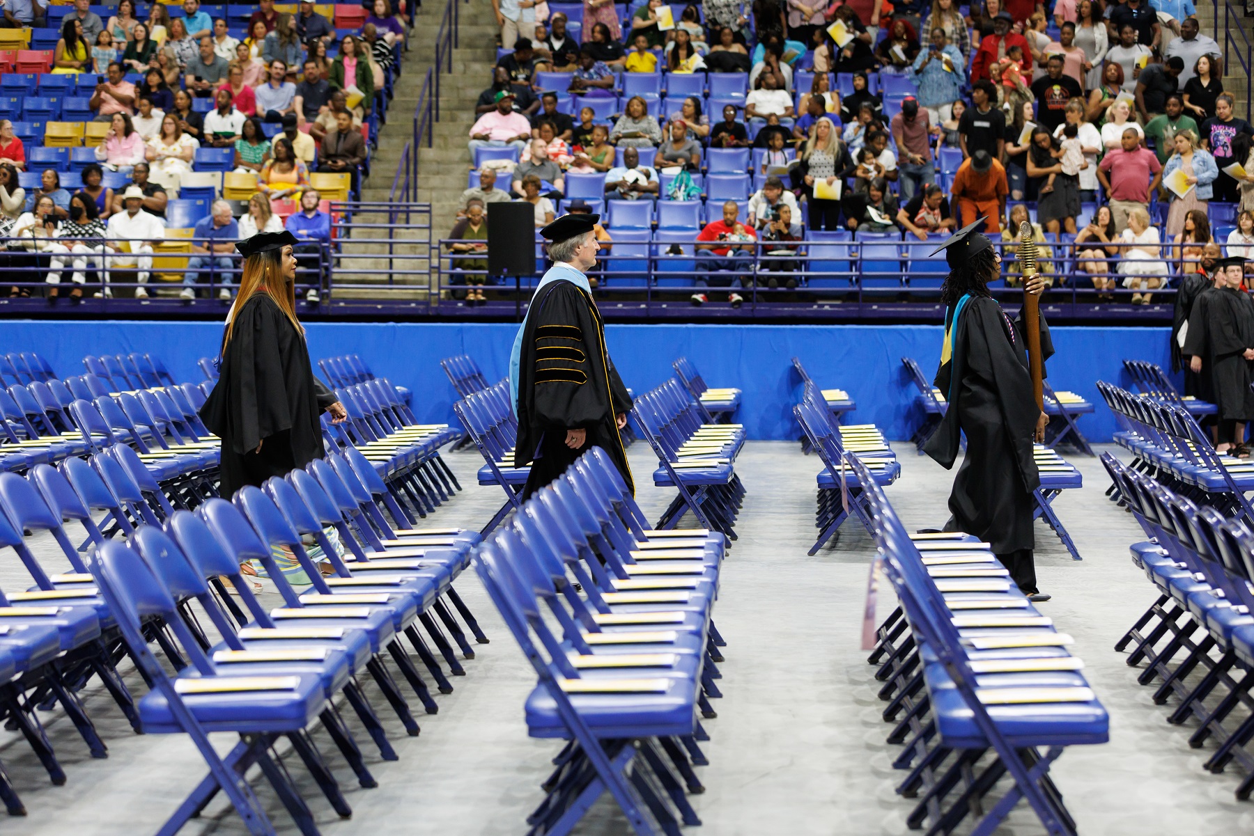 Qadeerah Rasheed-Brown carries the FTCC Mace, followed by Dr. Mark Sorrells and Tammy Thurman as they walk to the stage in the Crown.