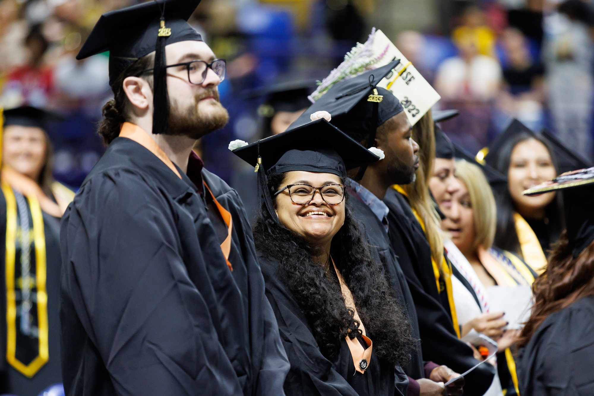 A graduate smiles at the camera while waiting to take her seat in the Crown.