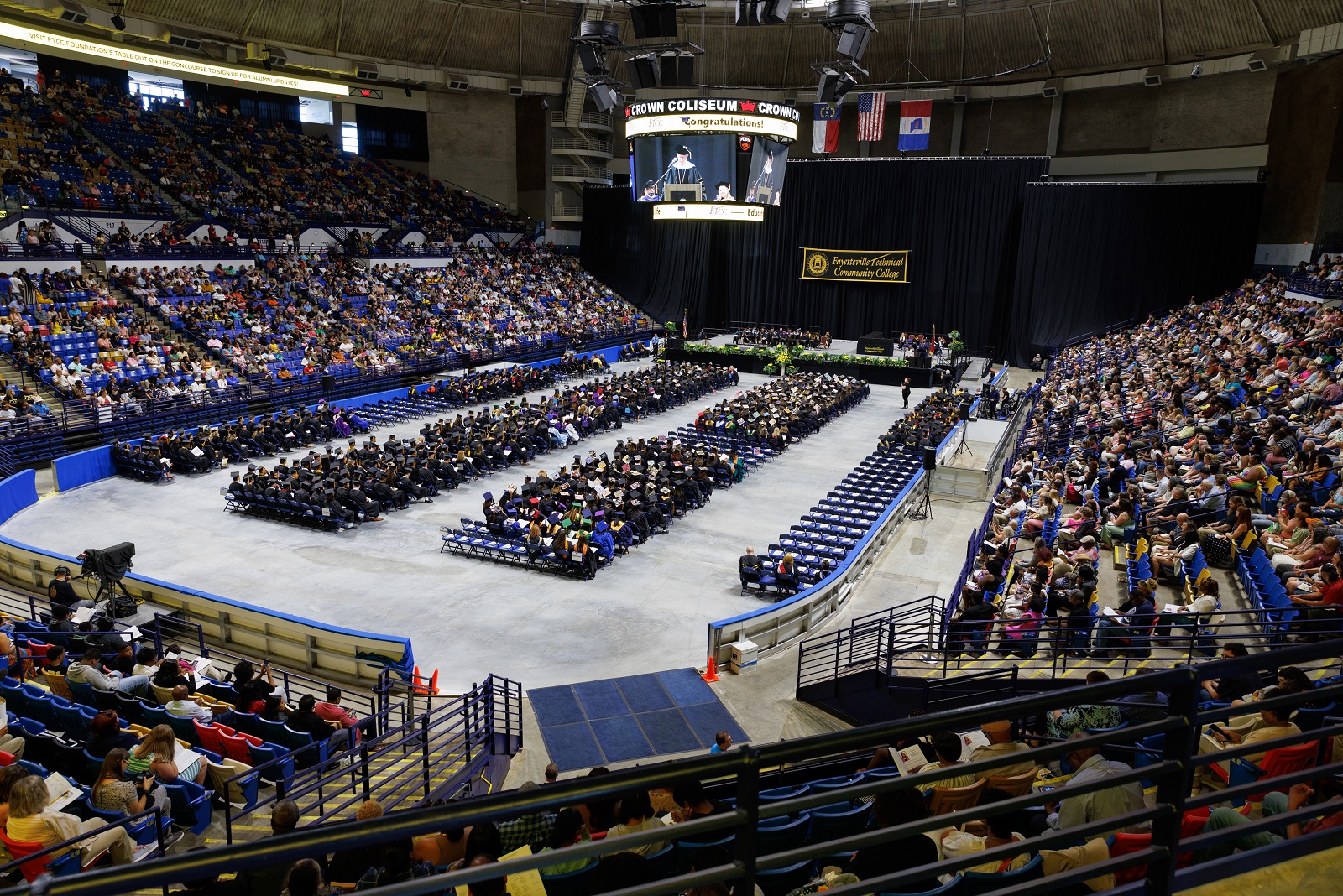 A wide photo shows the entire floor, stage and parts of the audience for the 10 a.m. ceremony in the Crown.