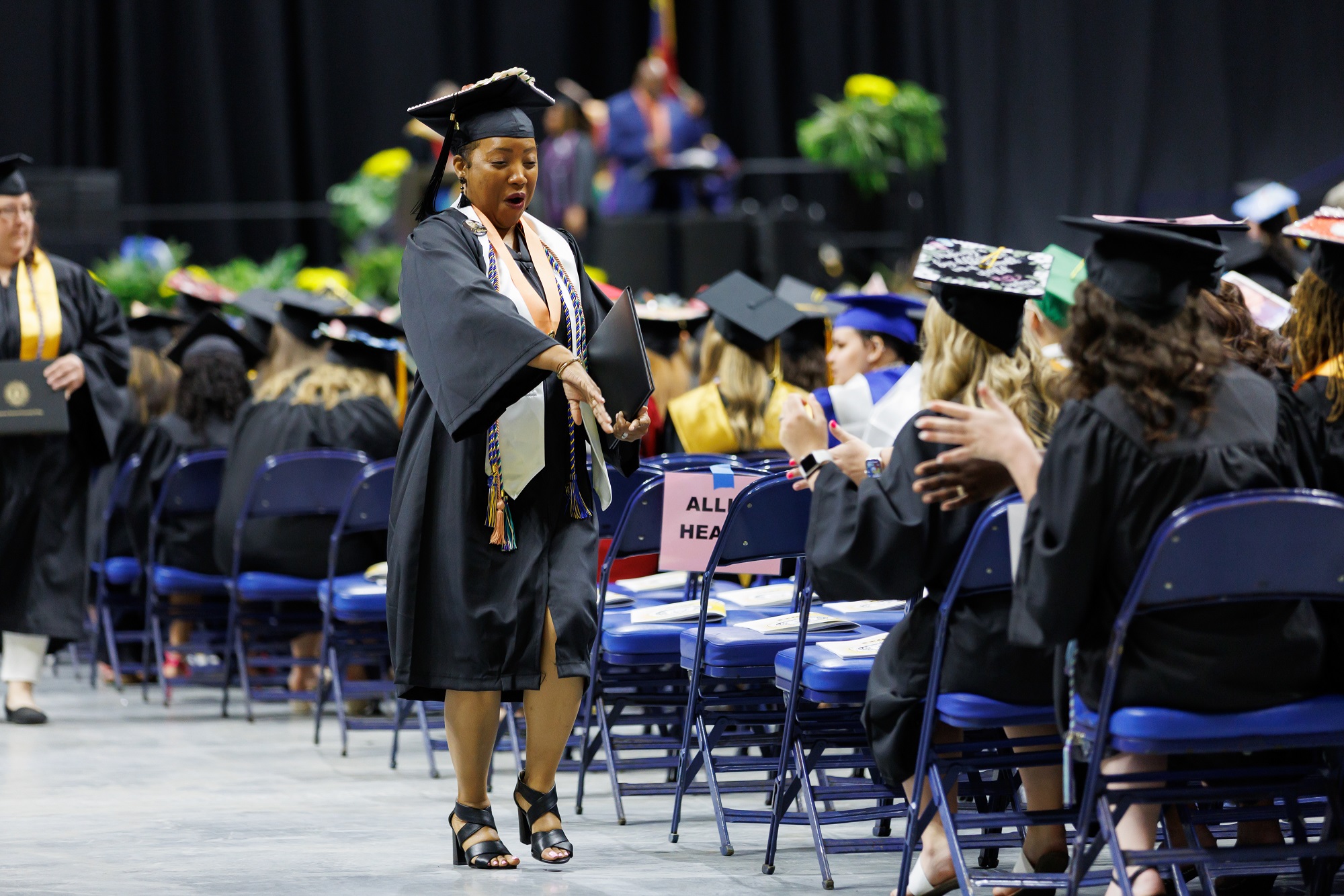 A graduate dances in the aisle on the way back to her seat.