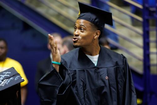 A graduate blows a kiss into the crowd.