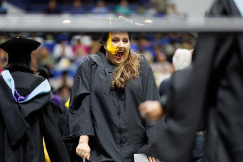 A graduate shouts in celebration as she crosses the stage.