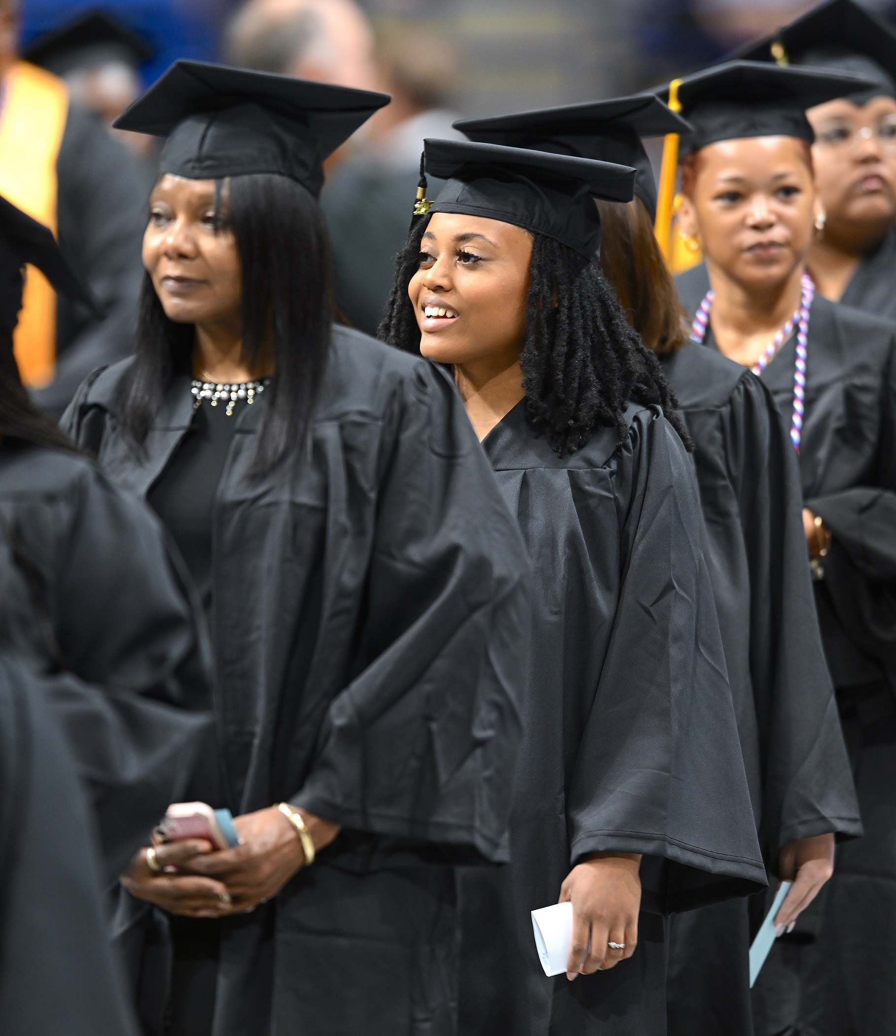 A graduate smiles at someone in the crowd as she enters the Crown floor.