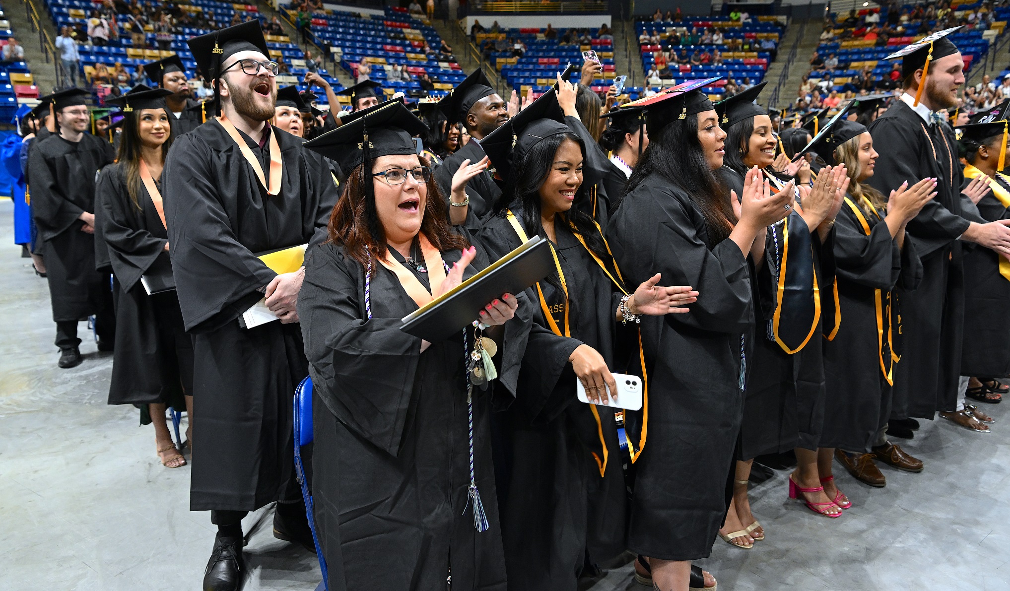 Row of graduates cheer after turning their tassels.