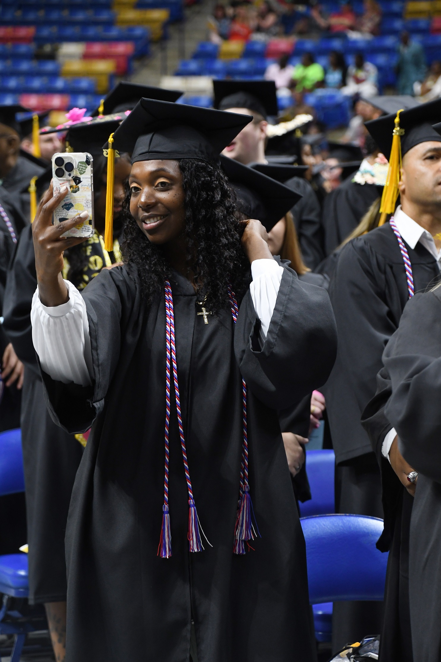 A graduate holds up her phone to take a selfie as she waits to be seated in the Crown.