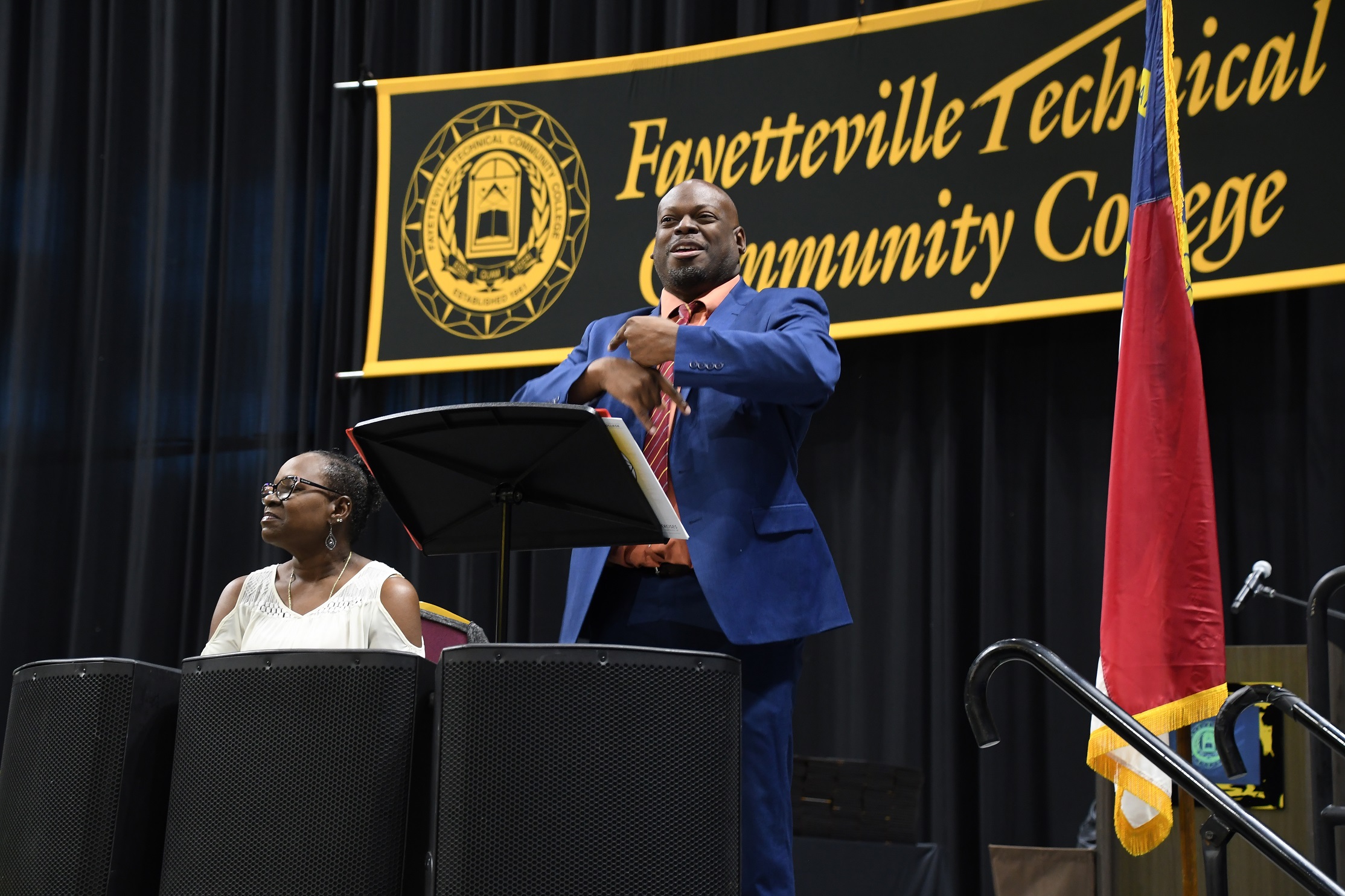 A sign language interpreter stands at the podium during the commencement ceremony.