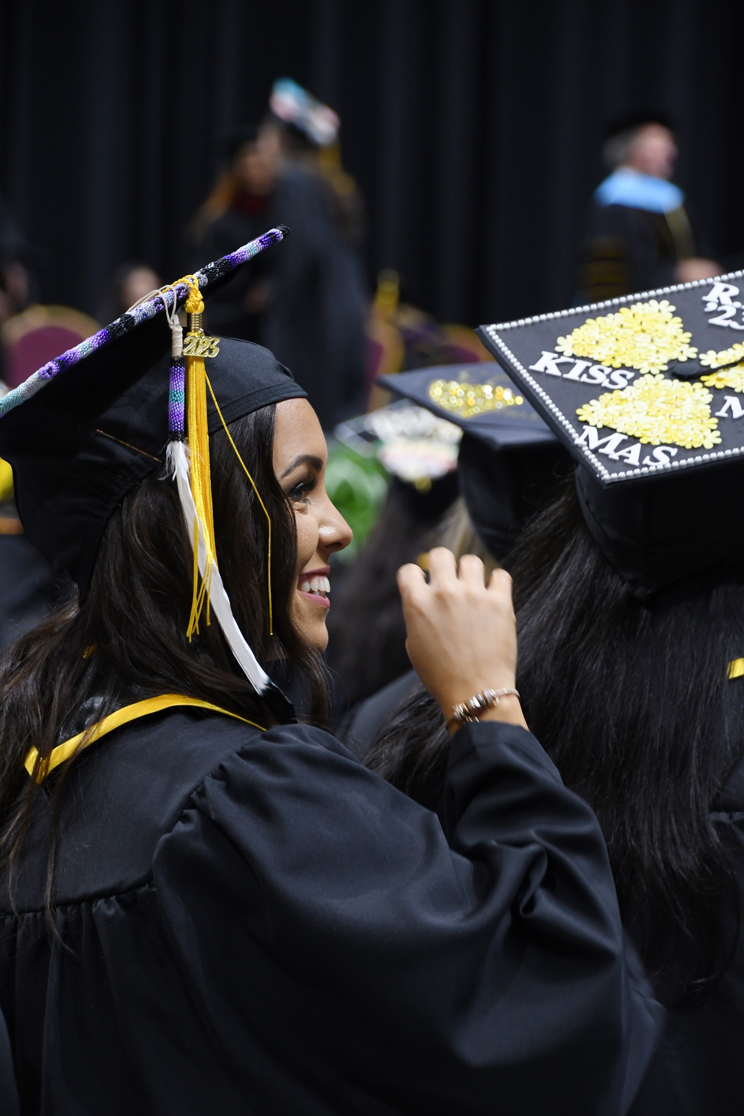A graduate, shown in profile, smiles up at the crowd.