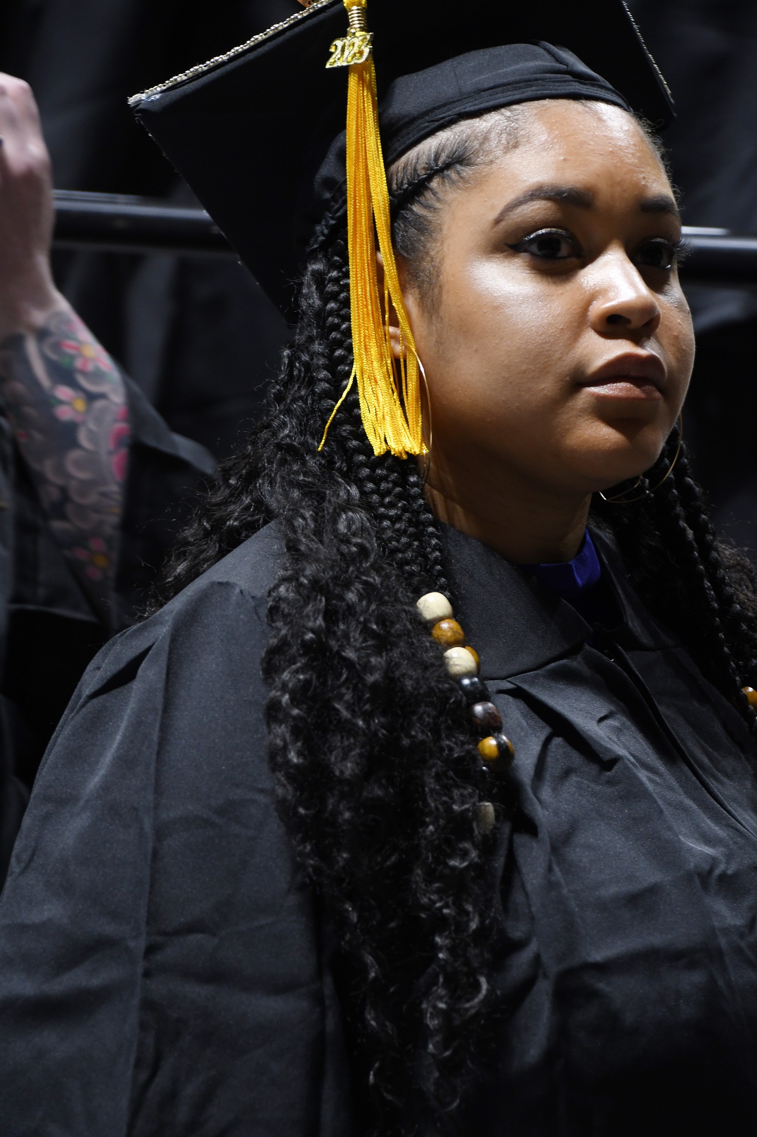 A close-up of a graduate wearing beads in her hair.