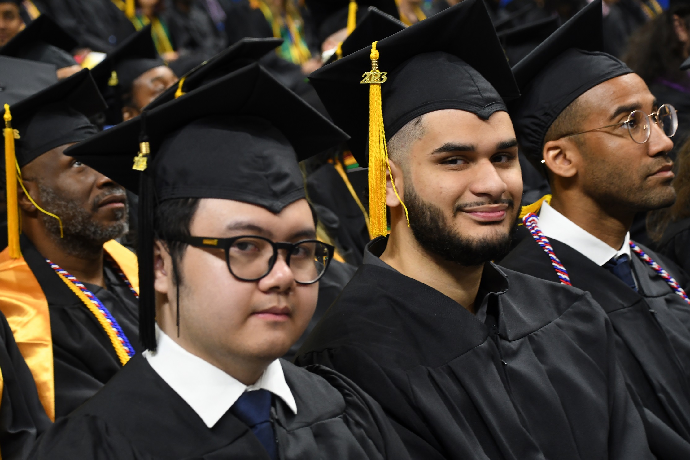 Graduates sit in a row during the Commencement ceremony.