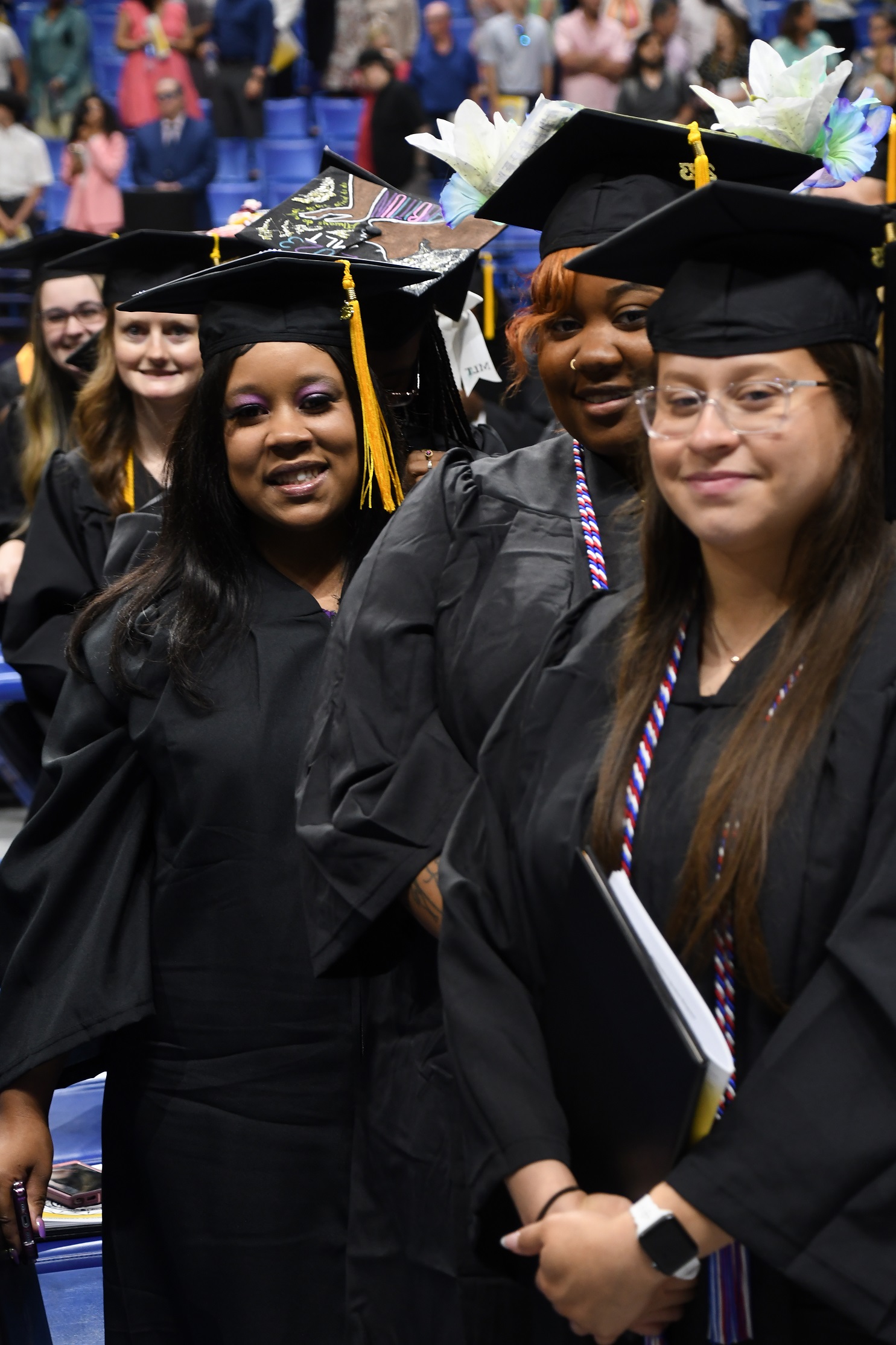 A group of graduates smiles at the camera.